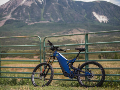 R15C leaning against a fence with mountains in the background R15C leaning against a fence with mountains in the background