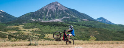 Optibike R17 E-Bike doing a wheelie in front of a large mountain