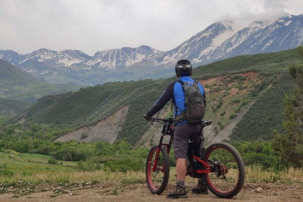 minn-creek-snowy-peaks A person on an Optibike looking out at snowy mountain peaks
