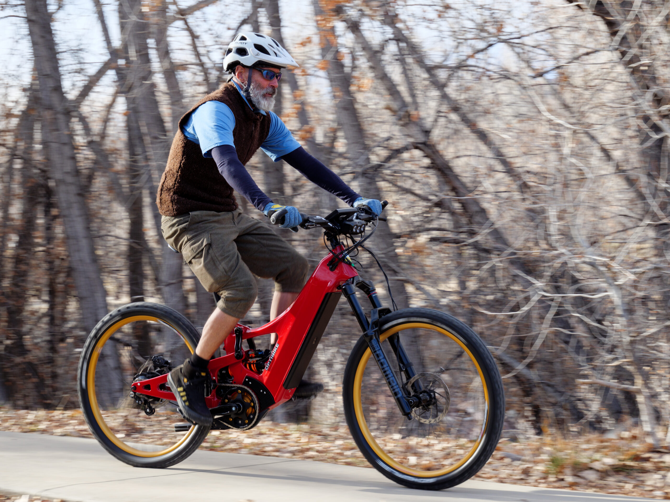 Man riding red electric bike on forest trail