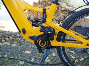 Yellow electric mountain bike motor and frame close-up